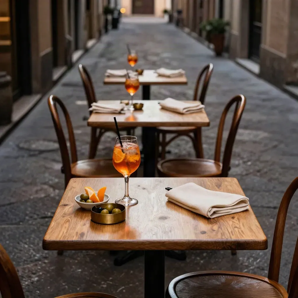 Tre tavolini vuoti con aperitivo caldo in una sera di Bologna, in sequenza diagonale.